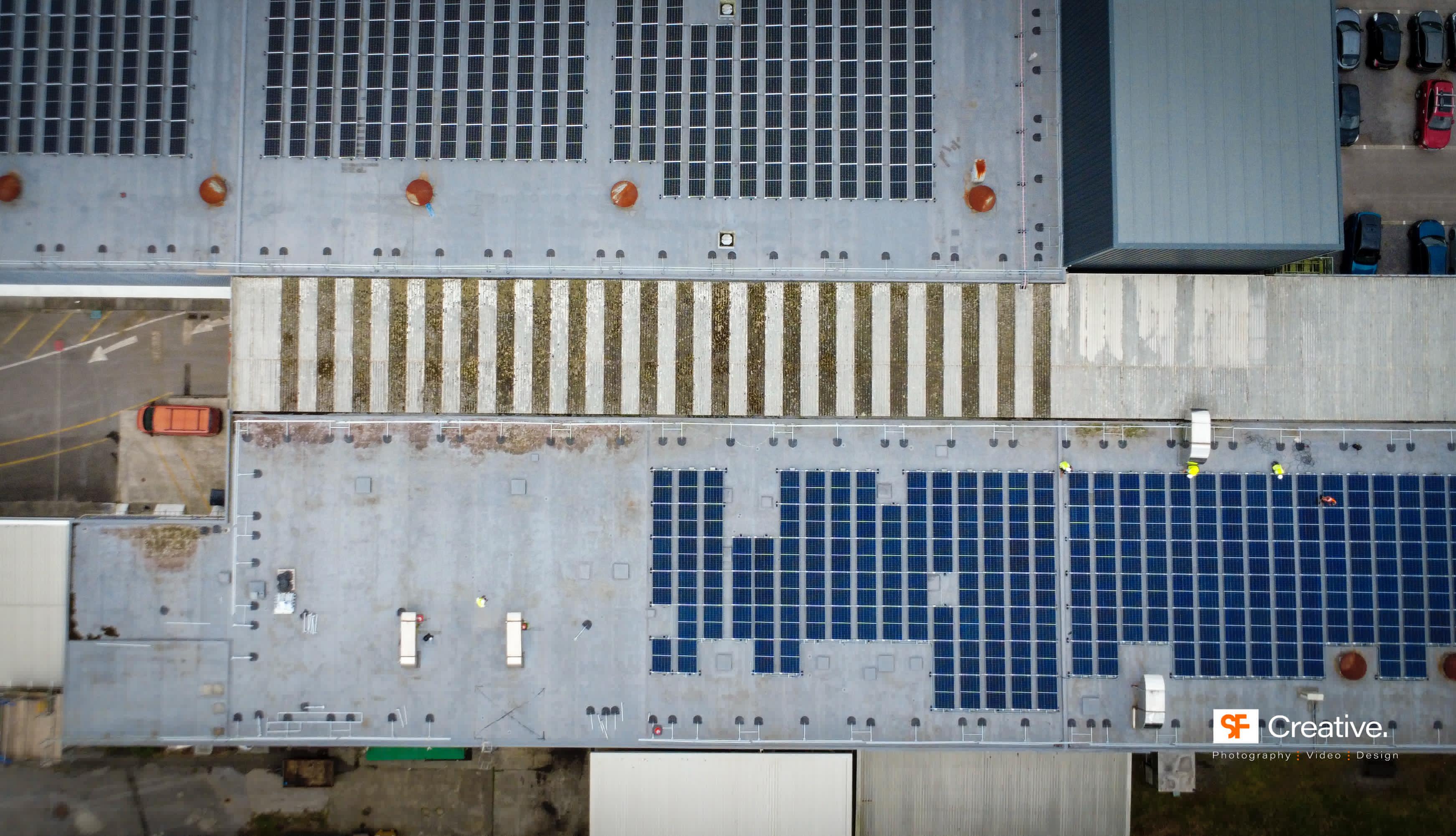 Solar panel installation in progress on industrial roof
